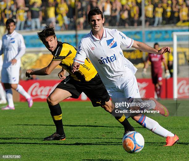 Gastón Pereiro of Nacional and Sebastián Píriz of Peñarol fight for de ball during a match between Nacional and Peñarol as part of round 12th of...