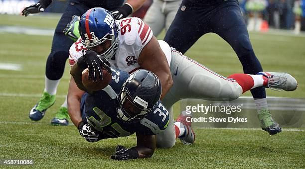 Running back Christine Michael of the Seattle Seahawks dives for the end zone as defensive tackle Mike Patterson of the New York Giants makes the...