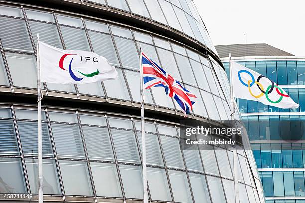 ipc, union and olympic flag near city hall in london - olympic hall stock pictures, royalty-free photos & images