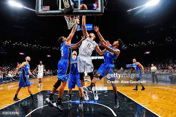 Brook Lopez of the Brooklyn Nets attempts a shot over Channing Frye and Elfrid Payton of the Orlando Magic in the second half at the Barclays Center...