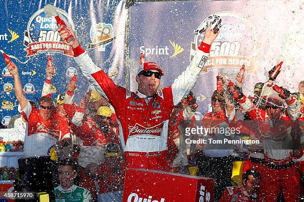 Kevin Harvick, driver of the Budweiser Chevrolet, celebrates in victory lane after winning the NASCAR Sprint Cup Series Quicken Loans Race for Heroes...