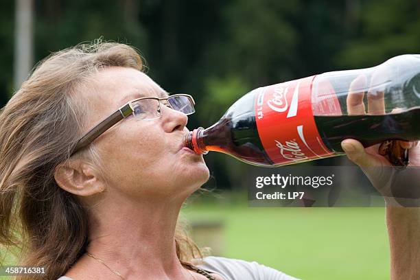 senior woman drinking cola - cola stock pictures, royalty-free photos & images