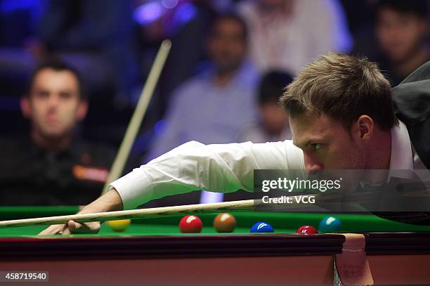 Judd Trump of England plays a shot against Ronnie O'Sullivan of England during their final match on day six of the 2014 Dafabet Champion of Champions...