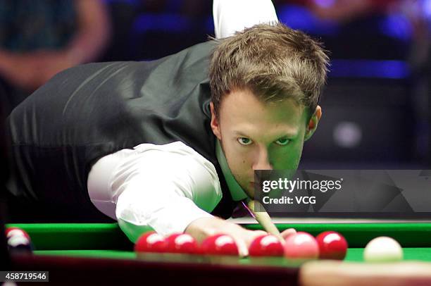 Judd Trump of England plays a shot against Ronnie O'Sullivan of England during their final match on day six of the 2014 Dafabet Champion of Champions...