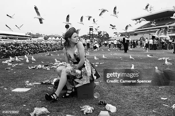 Racgoes sits on an esky on the public lawn following the final race on Stakes Day at Flemington Racecourse on November 8, 2014 in Melbourne,...