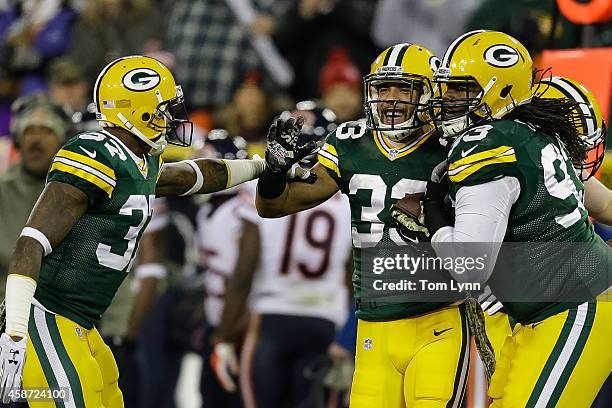 Micah Hyde of the Green Bay Packers celebrates with Sam Shields and Josh Boyd after intercepting the ball in the first quarter during the NFL game...