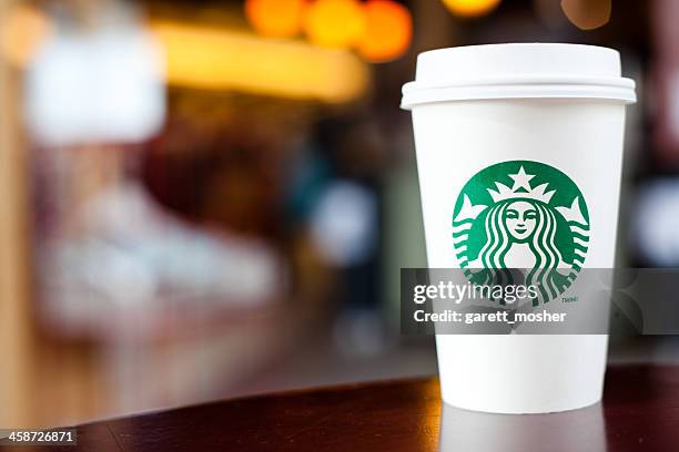 grande starbucks to go cup on table - starbucks drink stock pictures, royalty-free photos & images