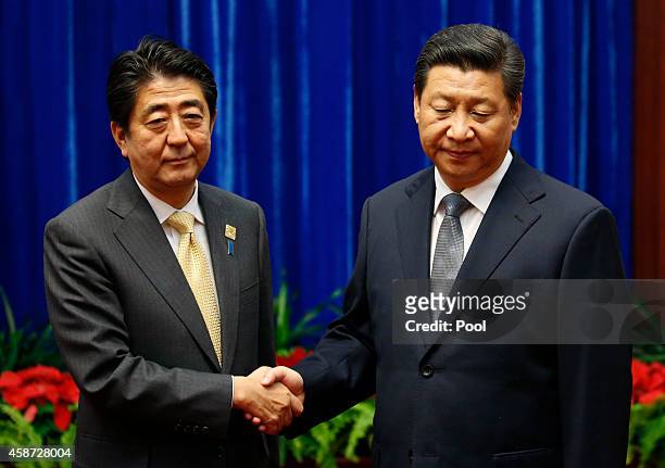 Japan's Prime Minister Shinzo Abe shakes hands with China's President Xi Jinping , during their meeting at the Great Hall of the People, on the...