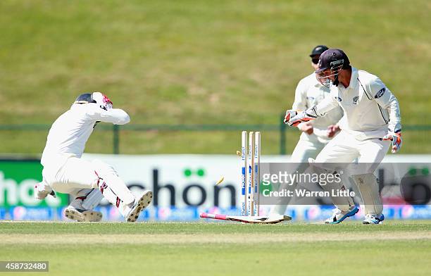Ahmed Shehzad of Pakistan is hit on the head and tumlbes into his wicket from the bowling of Corey Anderson of New Zealand during day two of the...