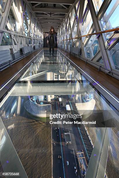 Visitor crosses Tower Bridge's new glass walkway on November 10, 2014 in London, England. Unveiled today the glass floor panels along the bridge's...