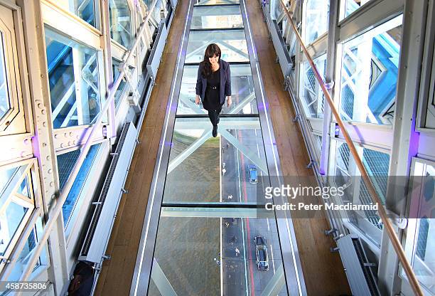 Visitor crosses Tower Bridge's new glass walkway on November 10, 2014 in London, England. Unveiled today the glass floor panels along the bridge's...