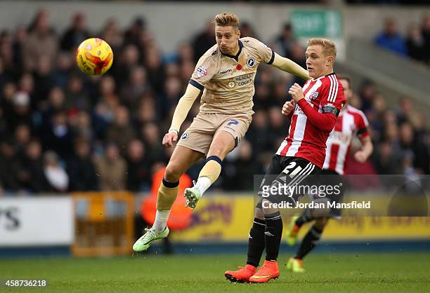 Lee Martin of Millwall takes a shot on goal under pressure from Alex Pritchard of Brentford during the Sky Bet Championship match between Millwall...