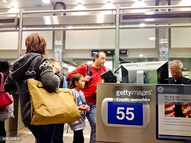u.s. immigration officer checking documents of tourists - customs agent stock pictures, royalty-free photos & images
