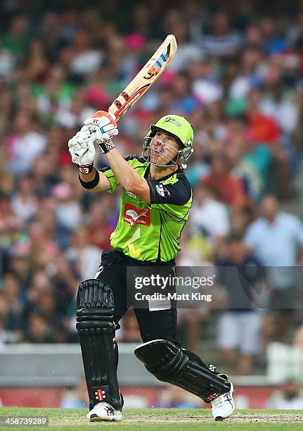 David Warner of the Thunder hits for six during the Big Bash League match between the Sydney Sixers and Sydney Thunder at SCG on December 21, 2013 in...