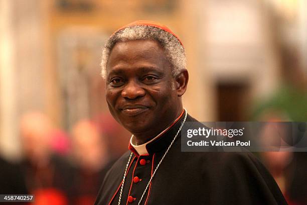 Ghanaian cardinal Peter Kodwo Appiah Turkson waits to exchange Christmas greetings with Pope Francis at the Clementina Hall on December 21, 2013 in...