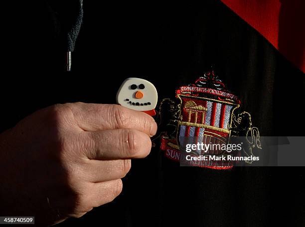 Fan pins a snowman badge to his top during the Barclays Premier League match between Sunderland and Norwich City at the Stadium of Light on December...