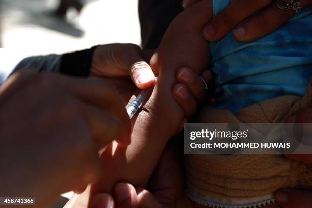 Doctor administers a measles vaccine to a Yemeni child during an immunization campaign at a health center on November 10 in the capital Sanaa. The...