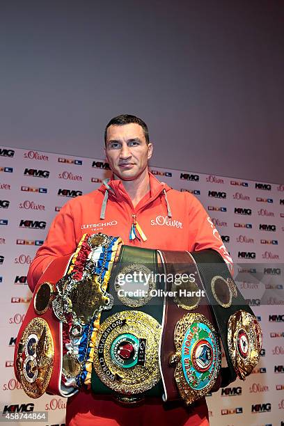 Wladimir Klitschko of Ukraine poses with the title belts on during a press conference ahead of the upcoming heavyweight boxing title fight between...