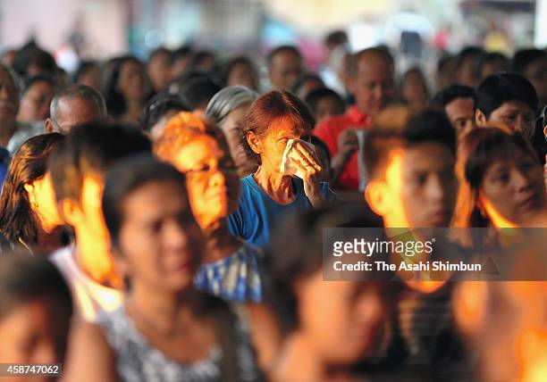 People pray for the victims at a mass on November 8, 2014 in Tacloban, Leyte, Philippines. People lined the roads with candles all across Tacloban...