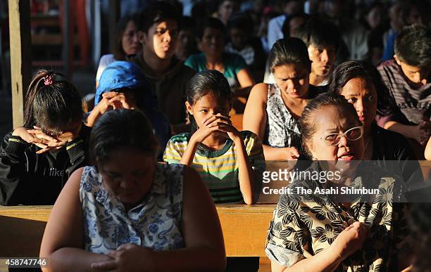 People pray for the victims at a mass on November 8, 2014 in Tacloban, Leyte, Philippines. People lined the roads with candles all across Tacloban...
