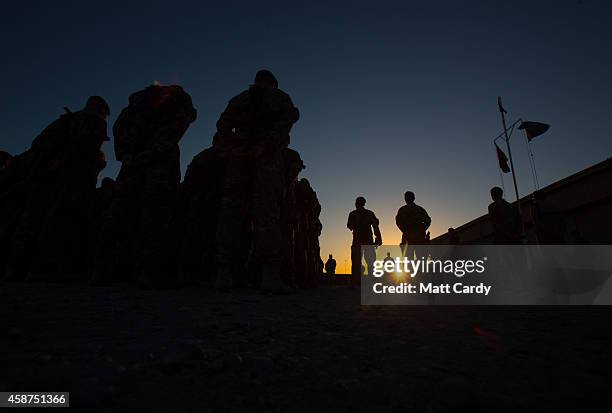 British troops attend a 904 Expeditionary Air Wing sunset flag lowering and end of mission ceremony at Kandahar airfield on November 10, 2014 in...