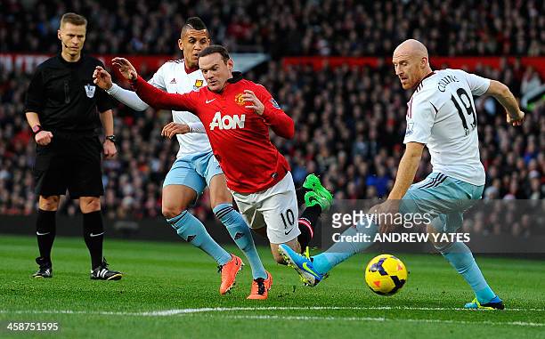 Manchester United's English striker Wayne Rooney vies with West Ham United's English midfielder Ravel Morrison and West Ham United's Welsh defender...
