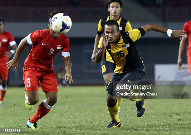 Mohd Azmi of Malaysia competes for the ball with Mohamad Sahil Suhaimi of Singapore during the Men's 3rd placing play-off Football Competition during...