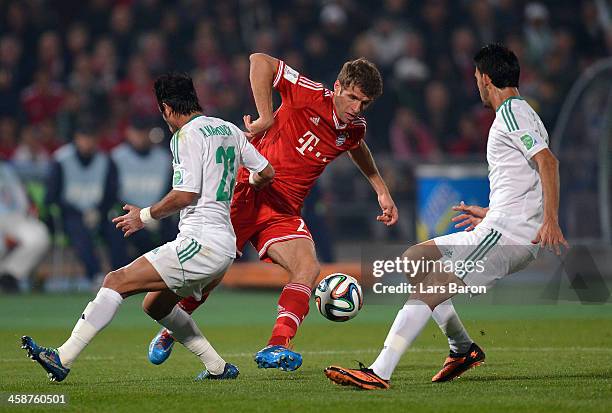 Thomas Mueller of Muenchen is challenged by Adil Karrouchy of Casablanca during the FIFA Club World Cup Final between FC Bayern Muenchen and Raja...