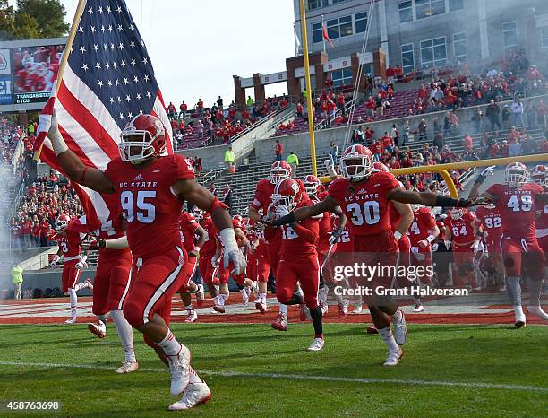 Art Norman of the North Carolina State Wolfpack carries the flag onto the field during their game against the Georgia Tech Yellow Jackets at...