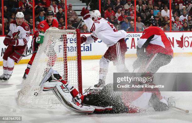 Antoine Vermette of the Phoenix Coyotes scores a second period goal against Craig Anderson and Bobby Ryan of the Ottawa Senators as Lauri Korpikoski...