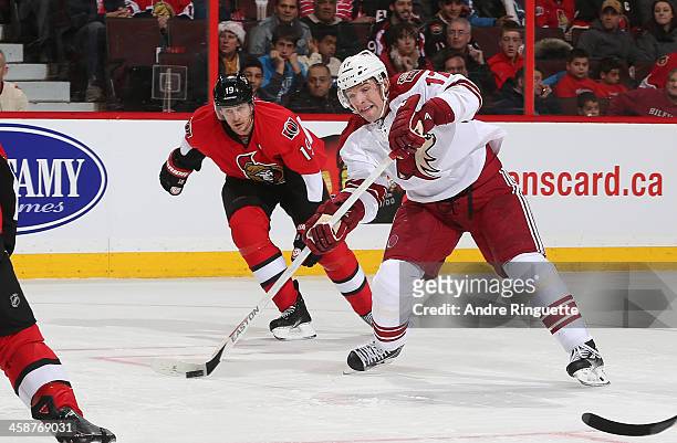 Radim Vrbata of the Phoenix Coyotes shoots the puck, scoring a second period goal as Jason Spezza of the Ottawa Senators follows on the play at...