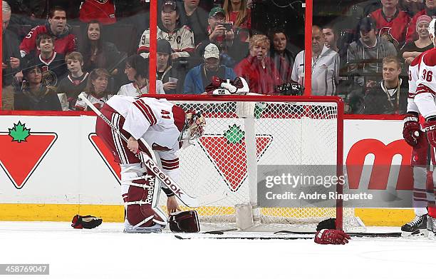 Mike Smith of the Phoenix Coyotes picks up his gloves after an altercation during the second period of a game against the Ottawa Senators at Canadian...