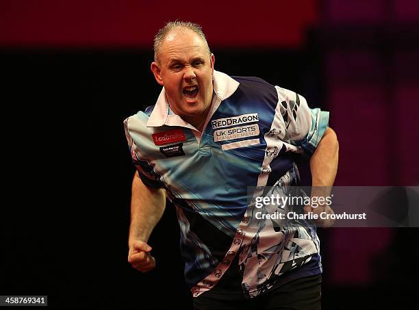 Ian White of England celebrates winning his second round match against Kim Huybrechts of Belgium during the Ladbrokes.com World Darts Championship on...