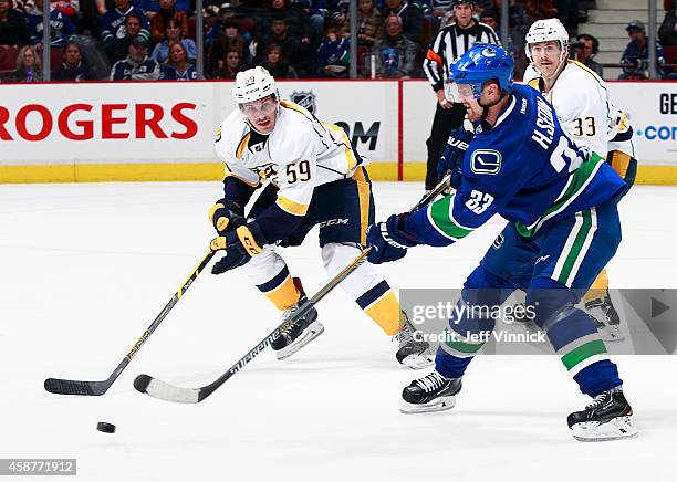 Roman Josi of the Nashville Predators looks on as Henrik Sedin of the Vancouver Canucks passes the puck up ice during their NHL game at Rogers Arena...