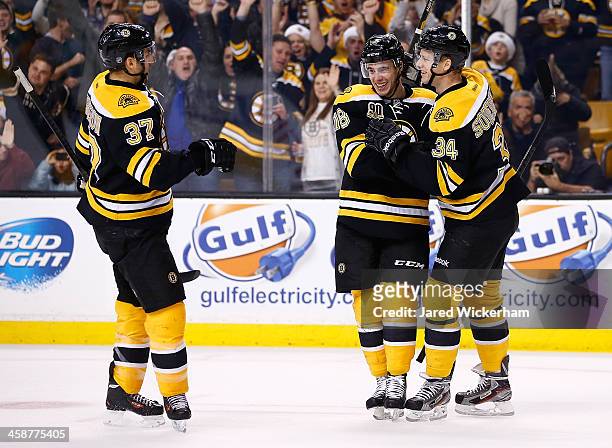 Reilly Smith of the Boston Bruins is congratulated by teammates Carl Soderberg and Patrice Bergeron after scoring a goal in the first period against...