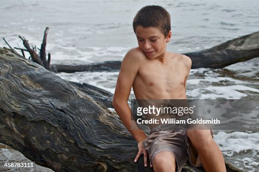 Boy Climbing Over Drift Wood High-Res Stock Photo - Getty Images