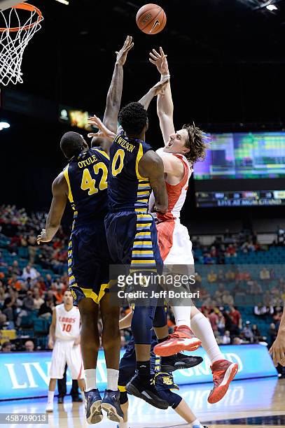 Cameron Bairstow of the New Mexico Lobos puts up a shot against Chris Otule and Jamil Wilson of the Marquette Golden Eagles during their game at the...