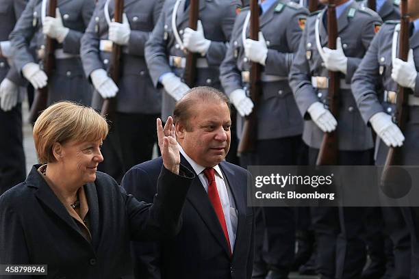 Angela Merkel, Germany's chancellor, left, and Nawaz Sharif, Pakistan's prime minister, review an honor guard ahead of a news conference at the...
