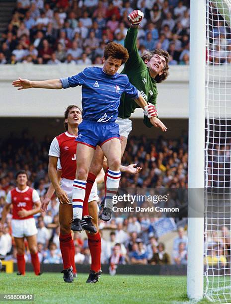 Arsenal goalkeeper Pat Jennings clears from Chelsea winger Pat Nevin as Arsenal defender Kenny Sansom looks on during a League Division One match...