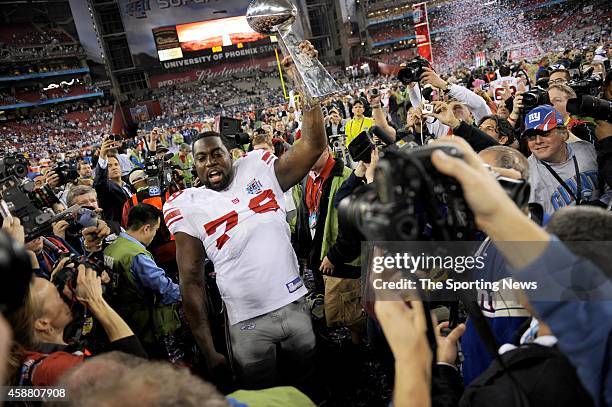 Guy Whimper of the New York Giants celebrates with the Lombardi Trophy after winning Super Bowl XLII against the New England Patriots on February 3,...