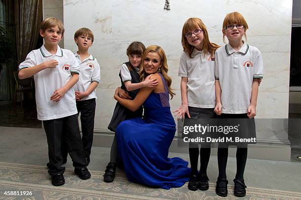 Katherine Jenkins poses for photographs with the Meath School choir during I CAN 'Million Lost Voices Appeal' gala concert and dinner at The Savoy...