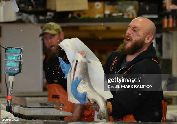 Fishmongers at the Pike Place Fish stall, throw fish in a routine that they started to speed up the workflow but has now made them a major tourist...