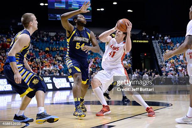 Cameron Bairstow of the New Mexico Lobos drives against Davante Gardner of the Marquette Golden Eagles during their game at the MGM Grand Garden...