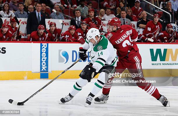 Jamie Benn of the Dallas Stars breaks in with the puck ahead of Oliver Ekman-Larsson of the Arizona Coyotes during the third period of the NHL game...