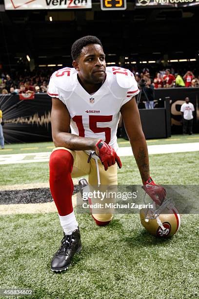 Michael Crabtree of the San Francisco 49ers kneels on the field prior to the game against the New Orleans Saints at the Mercedes-Benz Superdome on...