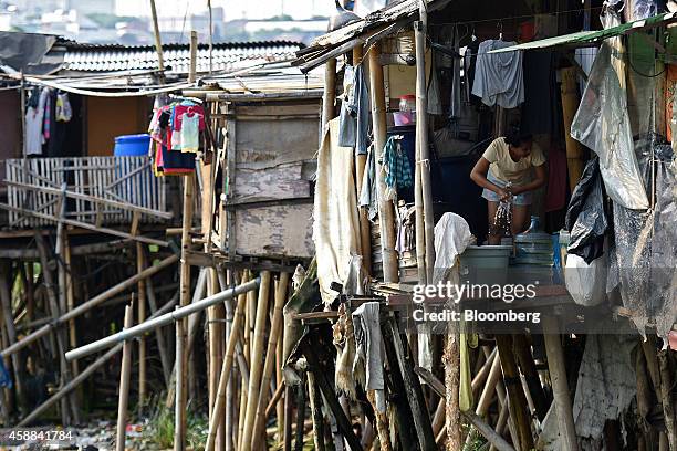 Woman wrings a cloth in a shanty house perched on stilts near the Pluit Dam area of North Jakarta, Indonesia, on Wednesday, Nov. 5, 2014. Jakarta, a...