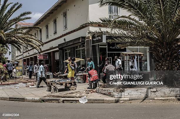 Vendors wait for customers on a sidewalk in the central Lusaka Businness district on November 12 a day after the burial of the late Zambian...