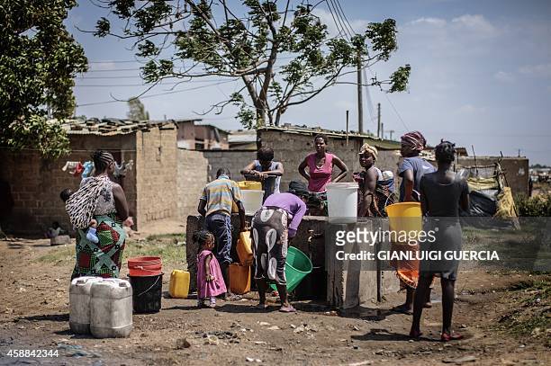 People collect water at a water point in the "compound" township on the oustkirts of Lusaka on November 12 a day after the burial of the late Zambian...