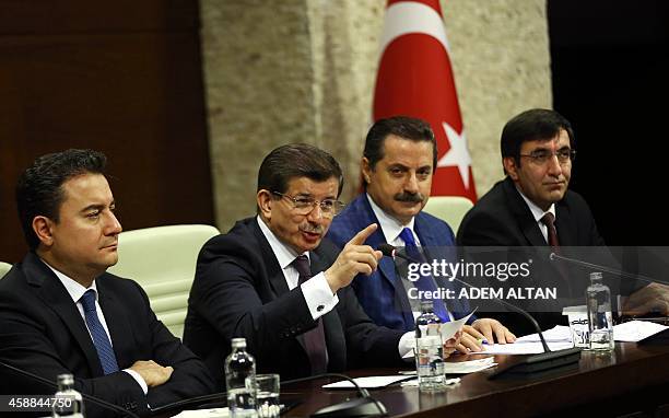 Turkish Prime Minister Ahmet Davutoglu gestures during a press briefing at the Prime Ministry Office in Ankara on November 12 flanked by Deputy Prime...