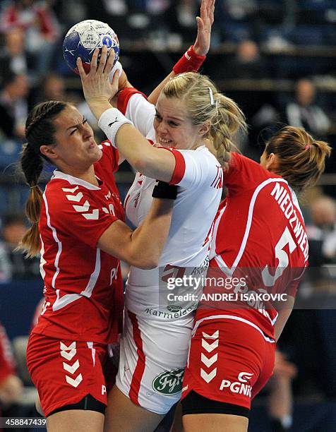 Denmark's Susan Torp Thorsgaard challenges Poland's Kinga Byzdra and Iwona Niedzwiedz during the 2013 Women's Handball World Championship match for...